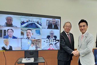 固く握手する、左から福田会長と矢倉克夫議員